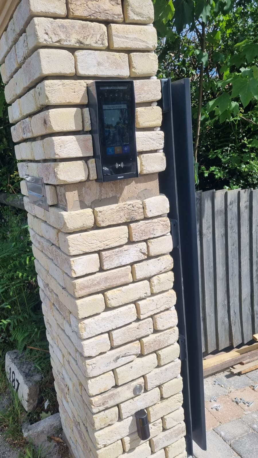 Akuvox E18C video intercom installed beside anthracite sliding gate by Grand Gates Automation.