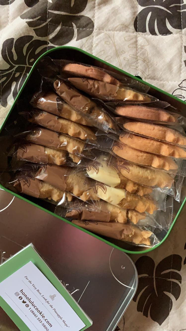 ホノルルクッキーカンパニーの缶パッケージに詰まったクッキーとその下に敷かれているトロピカル柄のキルティング布