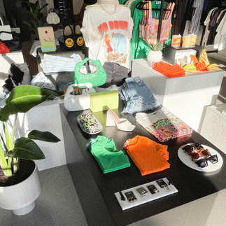 Tabletop display with summer accessories including sunglasses, sandals, and lightweight scarves.
