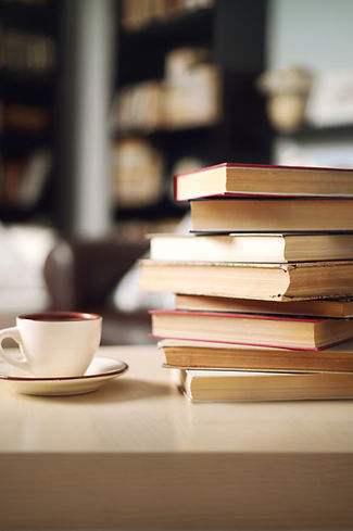 Pile of books and coffee representing training, education, and knowledge therapists bring to eating disorder therapy