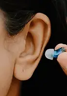 Ear with an hearing aid being put into the ear