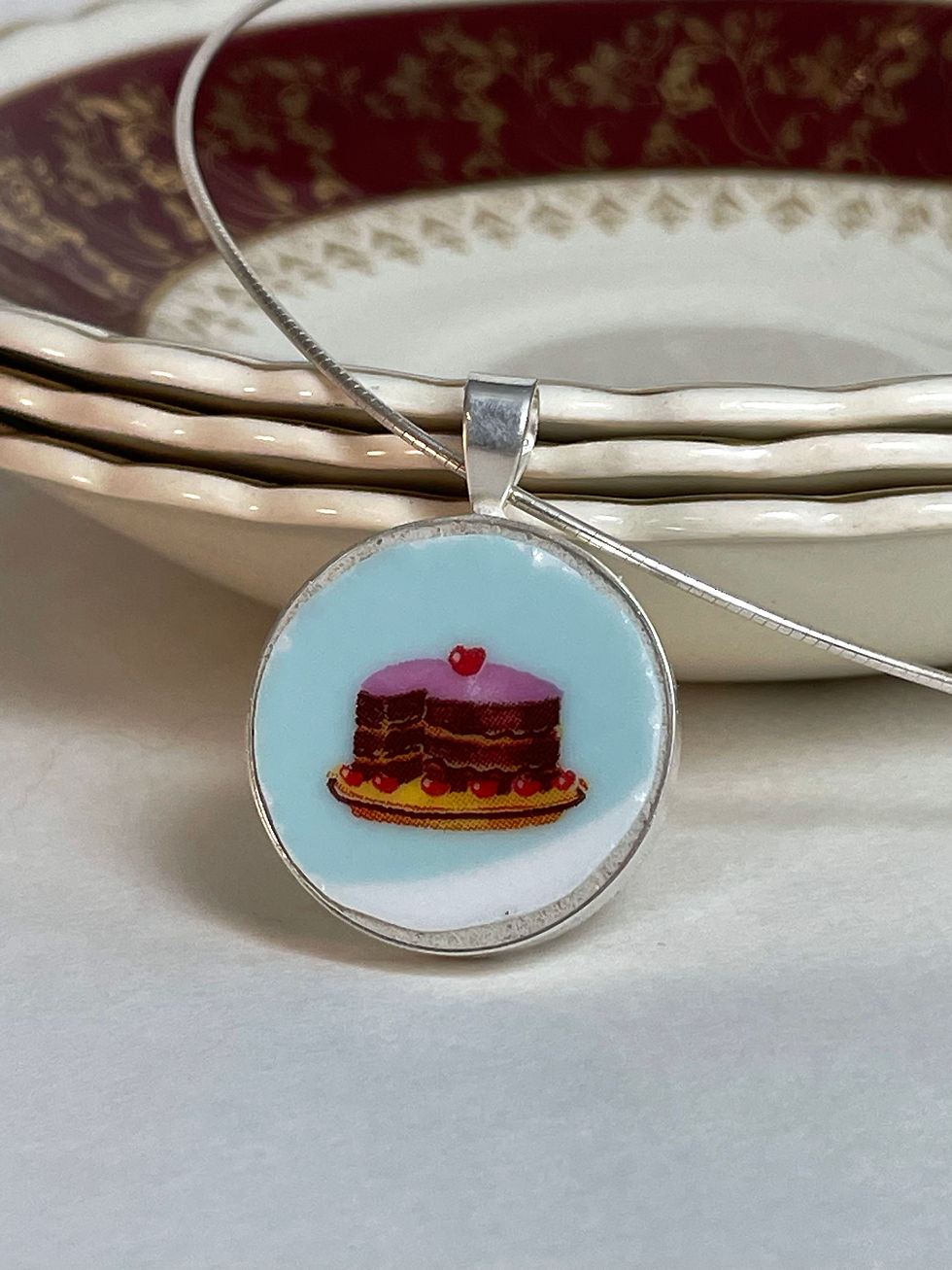 Thumbnail: round pendant with pink iced cake