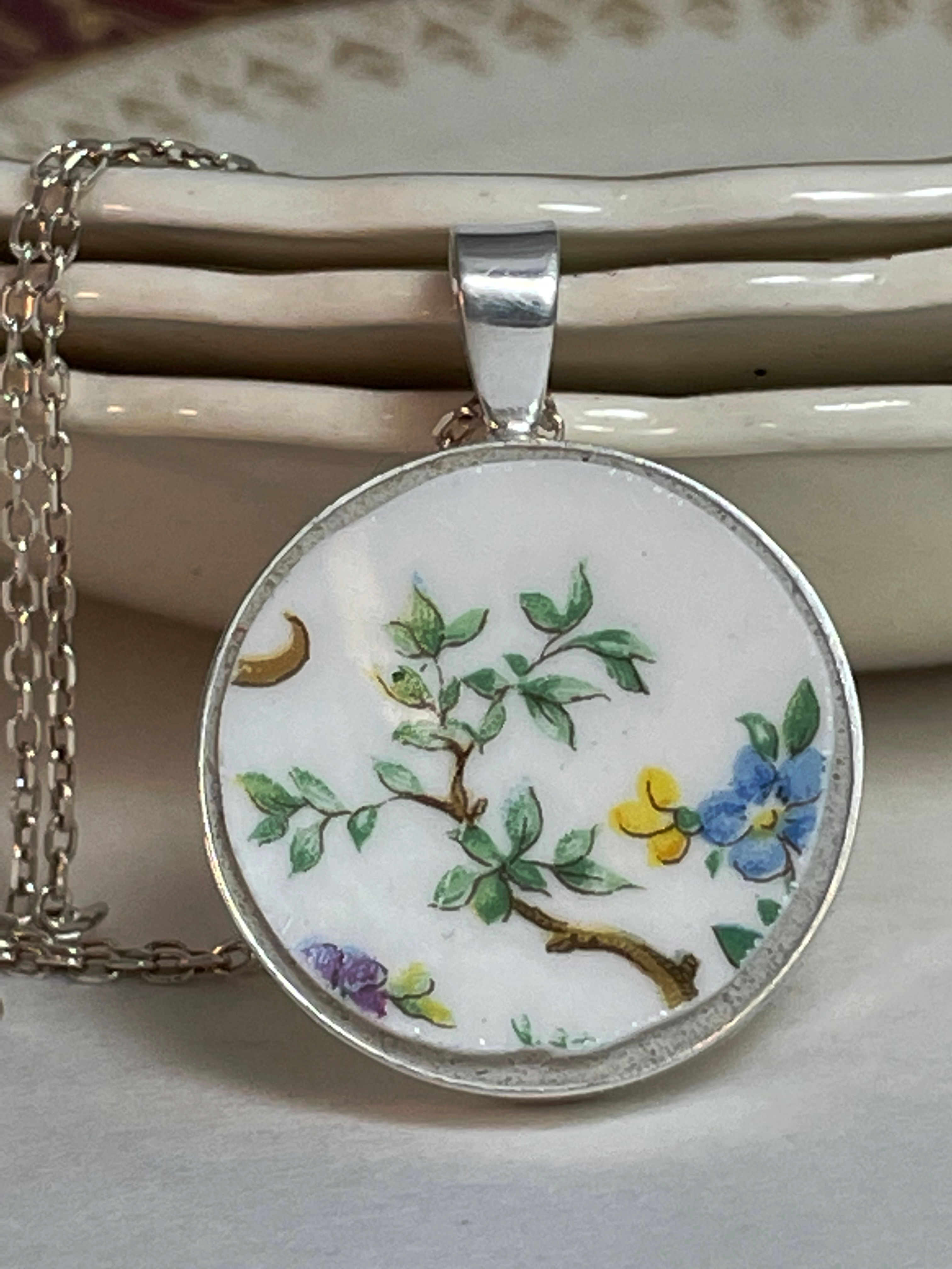round pendant with branch of leaves and some flowers