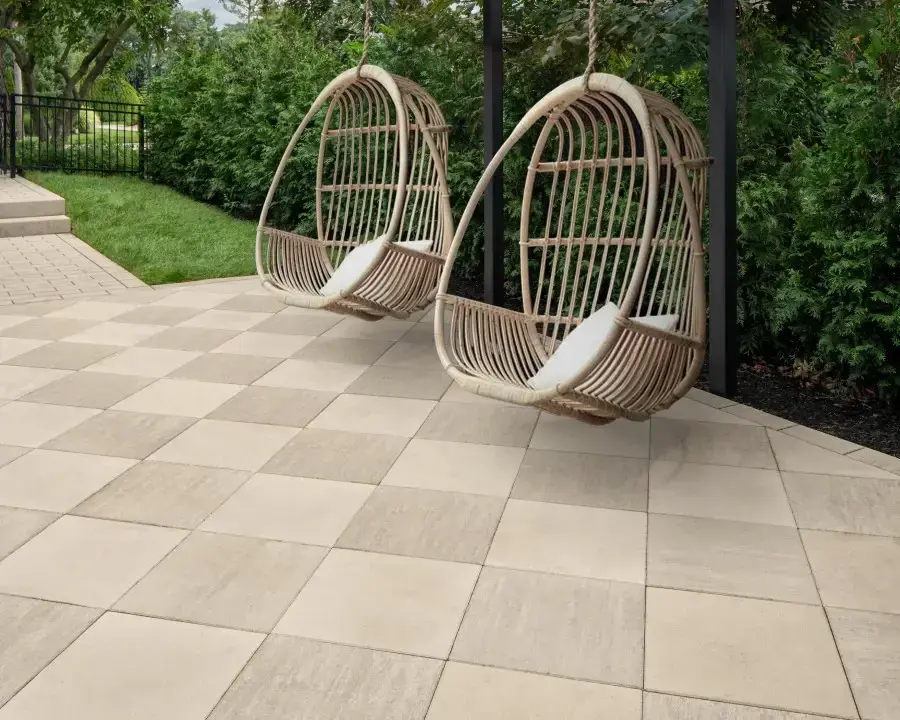 Deux chaises suspendues sur une terrasse en dalles.