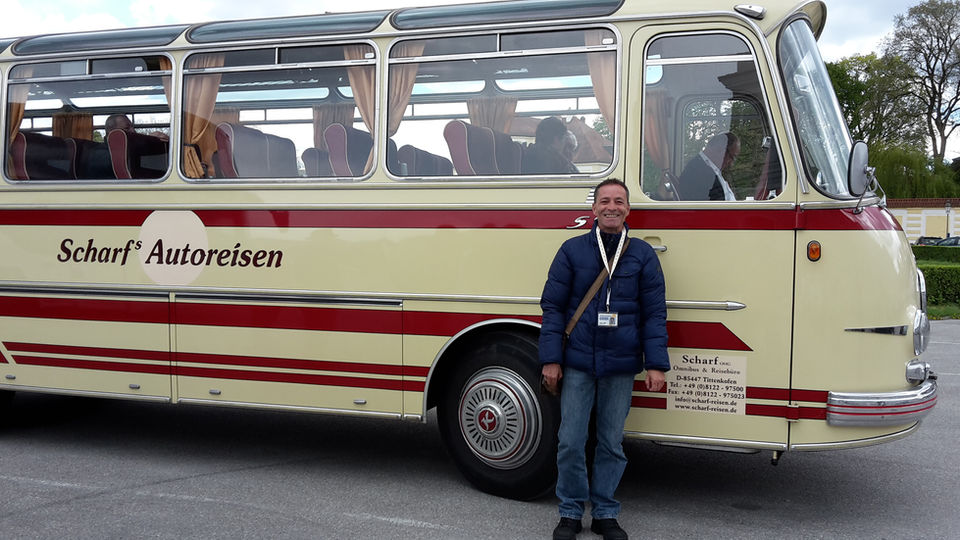 Guide vor einem historischen Reisebus