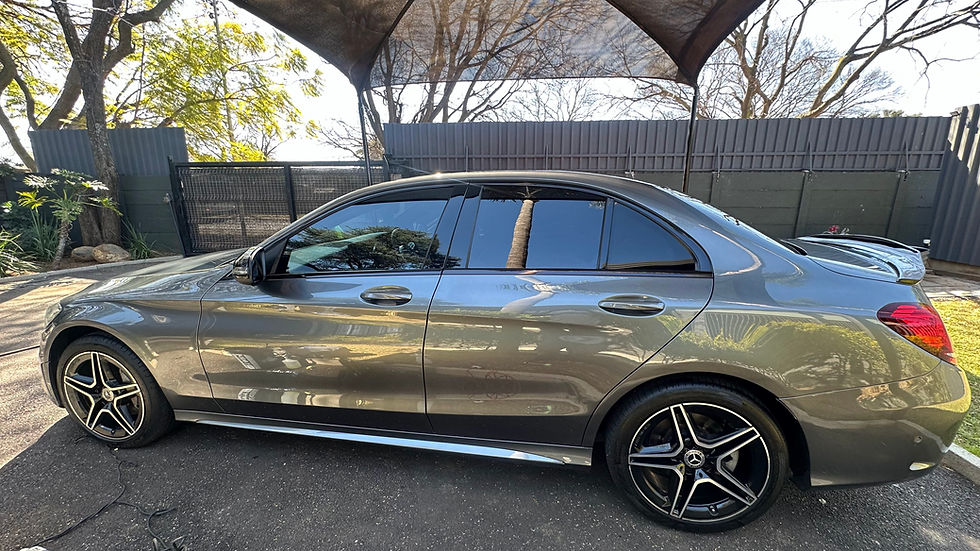 Side profile of a grey Mercedes-Benz sedan parked under a canopy