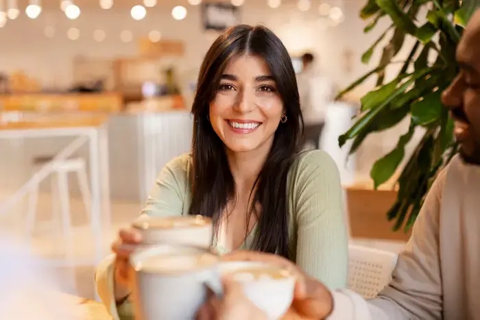 mujer feliz tomando un rico cafe acompañada de personas
