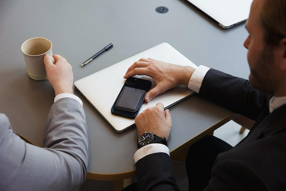 Plaud AI voice recorder mounted on a smartphone during a business meeting, highlighting AI voice wearable technology in professional environments.