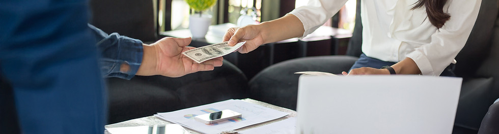 Dos manos intercambiando dinero en efectivo, representando una operación de cambio de divisas.