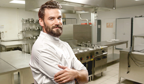 Chef într-o bucătărie profesională echipată cu utilaje HoReCa