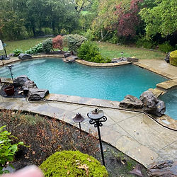 Beautiful backyard oasis with gorgeous and pristine swimming pool after algae treatment