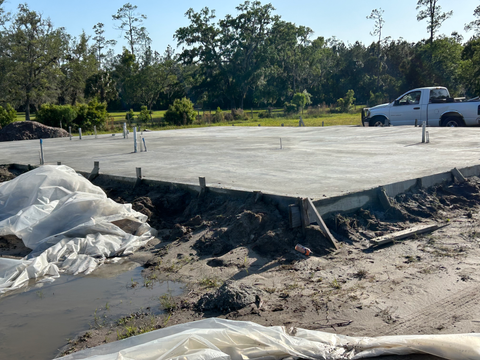 Concrete foundation with a truck, in a yard, construction site, daylight.