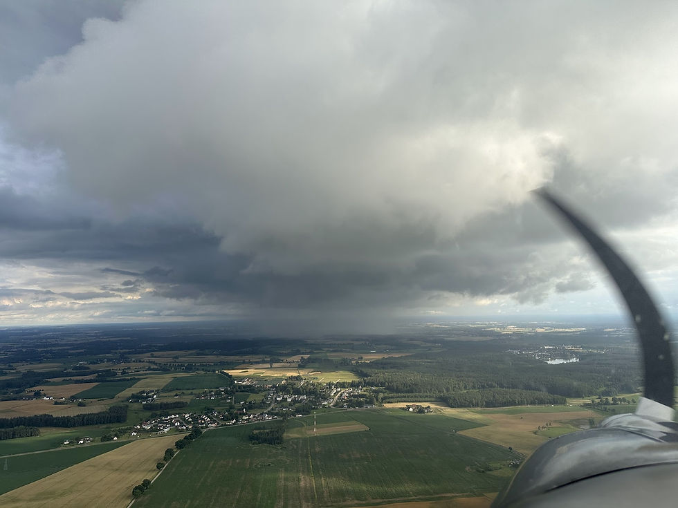 A rain shower obscures countryside ahead of a light aircraft.