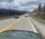 A vehicle drives through the burnt trees of Jasper of National Park