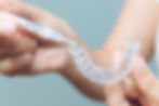 Person putting whitening gel into tooth trays