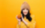 Person in hat holding a pumpkin