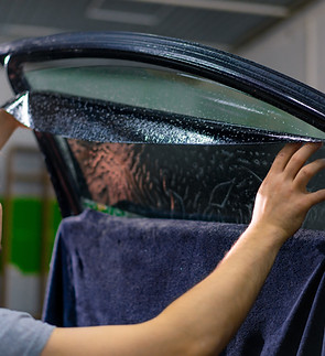 Male car service worker glue window tinting in luxury car detailing car repair the concept