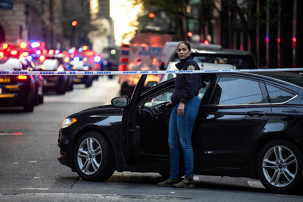 A New York police investigator exits her vehicle at the scene outside a Manhattan office building where two people were shot including a police officer, Monday, July 28, 2025, in New York