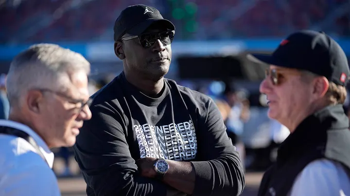 Michael Jordan and Curtis Polk, left, co-owners of 23XI Racing, watch during qualifying beside 23XI Racing President Steve Lauletta for a NASCAR Cup Series Championship auto race, Nov. 9, 2024, in Avondale, Arizona.