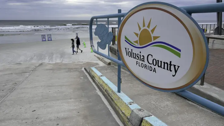 People walk past an access ramp at New Smyrna Beach in Volusia County, Florida, the area with the most shark attacks in the world, on February 23, 2024. (Photo by Jesus OLARTE / AFP) (Photo by JESUS OLARTE/AFP via Getty Images)