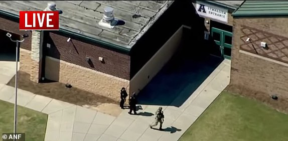 Heavily-armed police were seen entering the school as students were evacuated into the football stadium.
