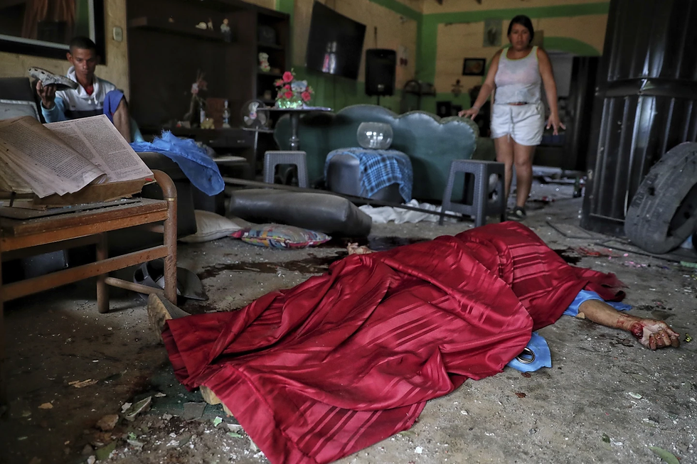 The body of Jose Carabali Galeano is covered in his living room, as his relatives look on, after a bomb exploded in Guachinte, Cauca Valley, Colombia, Tuesday, June 10, 2025