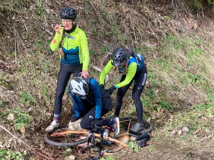 Cyclists from the Recycled Cycles Racing team pin down a young male cougar with a bike, as one of them calls 911. The cougar had attacked their friend Keri Bergere 15 minutes before this photo was taken.