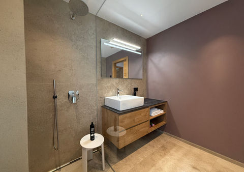 Bagno moderno con doccia e lavabo su mobile in legno