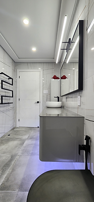 Modern bathroom renovation with floating vanity, LED mirror, matte black fixtures, and luxury marble-effect tiles – sleek 