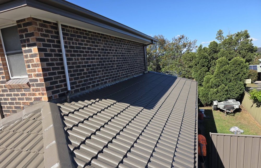 Freshly restored and coated tiled roof on a brick home