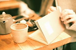 person opening book near coffee cip_edited_edited.jpg