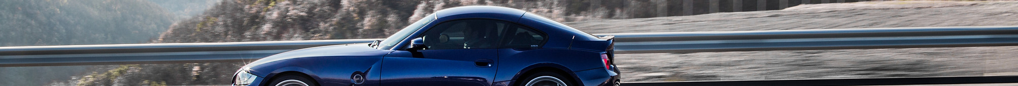 navy-blue-coupe-sedan-driving-highway-accross-mountains.jpg