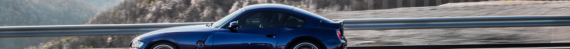 navy-blue-coupe-sedan-driving-highway-accross-mountains.jpg