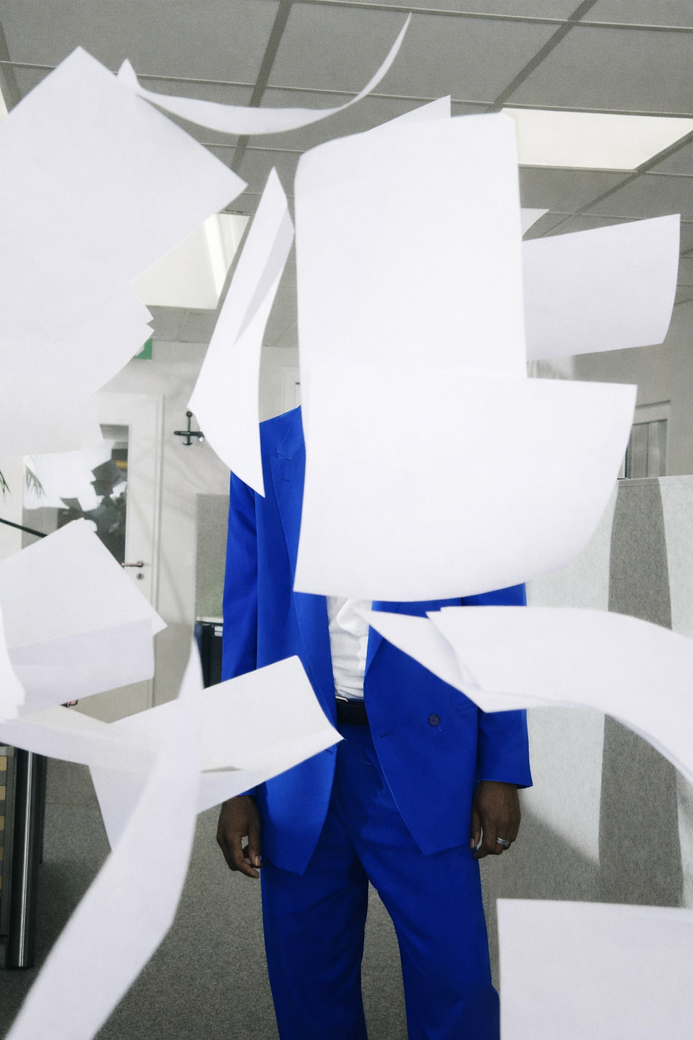 Man in blue suit, papers in motion.png