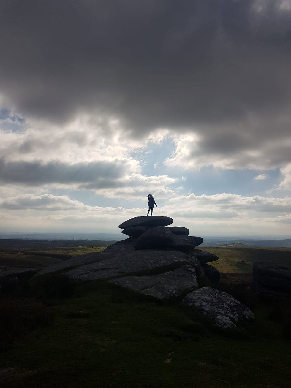 Dee from The Alchemy Room standing in silhouette at the summit of a hill after a hike, symbolizing feminine power, midlife transformation, and holistic wellness for women over 40.