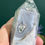 Thumbnail: hand holding moss agate tower close-up