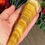 Thumbnail: Yellow Calcite Crystal Wand laying in hand