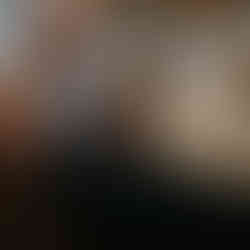 A blonde woman helps the groom put on his boutonniere