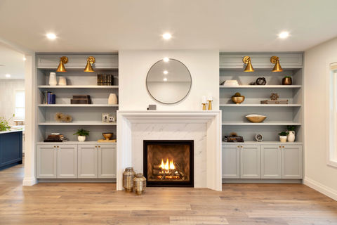 Bluish-grey custom millwork cabinets and centered fireplace living room wall.