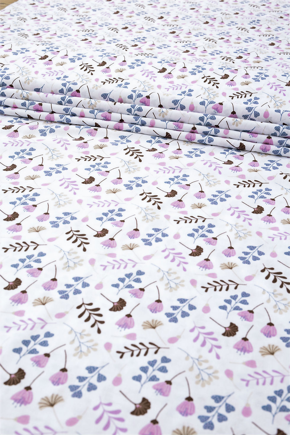 Zbliżenie na tkaninę bawełnianą z wzorem miłorzębu – naturalny, przewiewny materiał idealny na pościel i ubranka dziecięce.