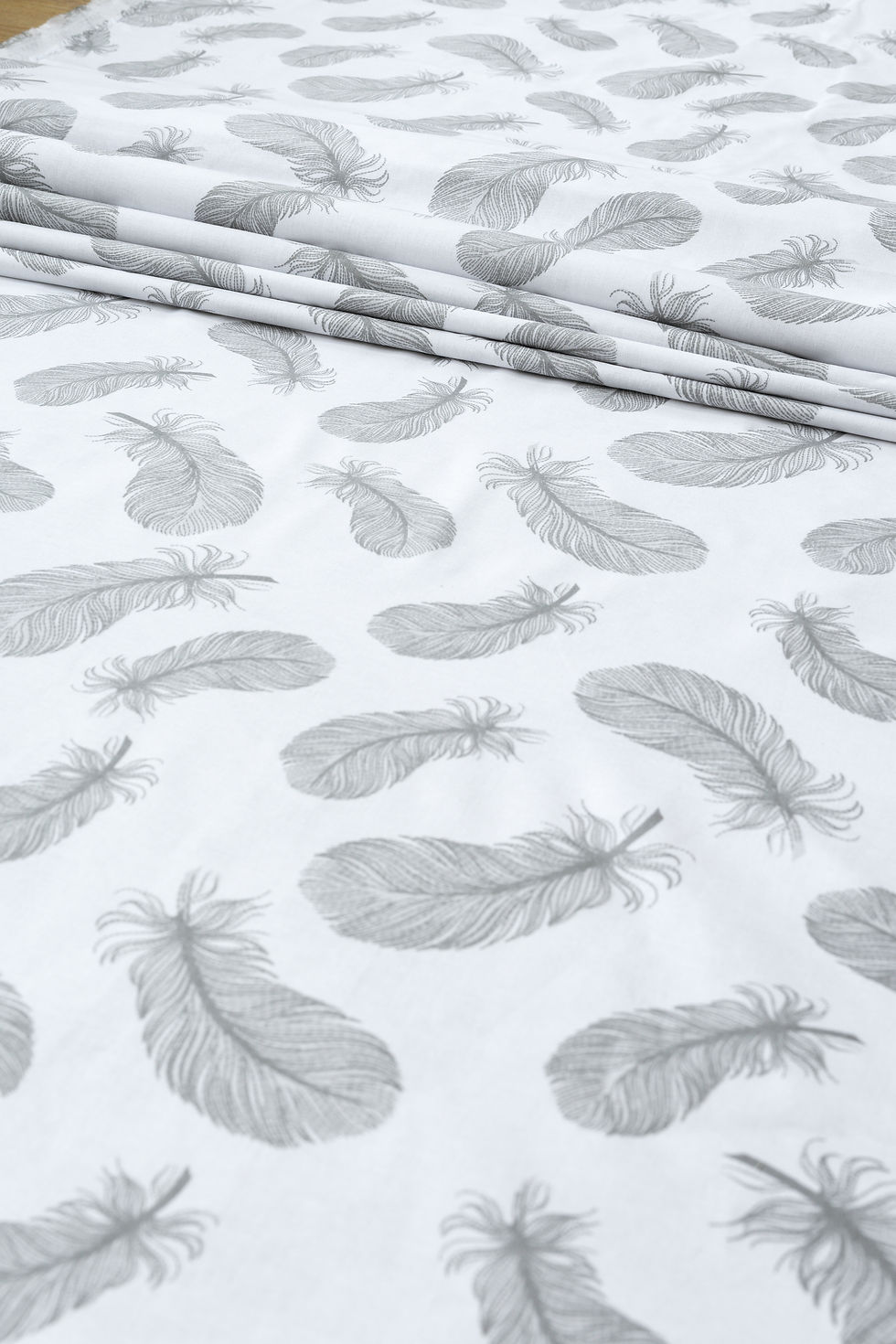 Materiał bawełniany z szarymi piórkami na białym tle – wysokiej jakości tkanina, bezpieczna dla dzieci