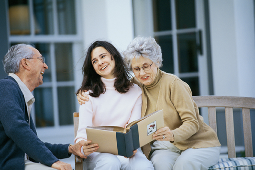 A photo of family members looking at a family photo album to determine how they are related to a deceased relative for probate and inheritance purposes.