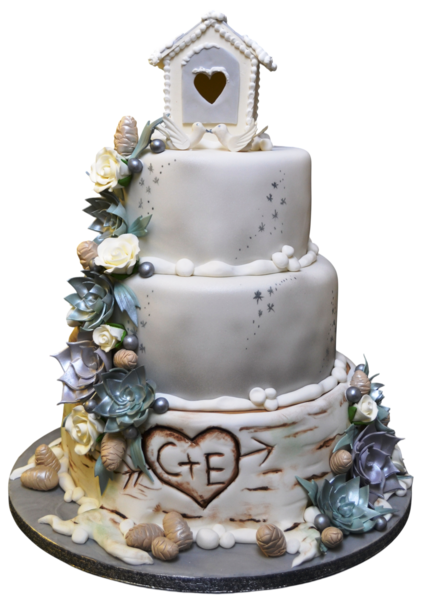 Three-tiered wedding cake with sugar paste flowers, birdhouse topper, and birch bark texture.