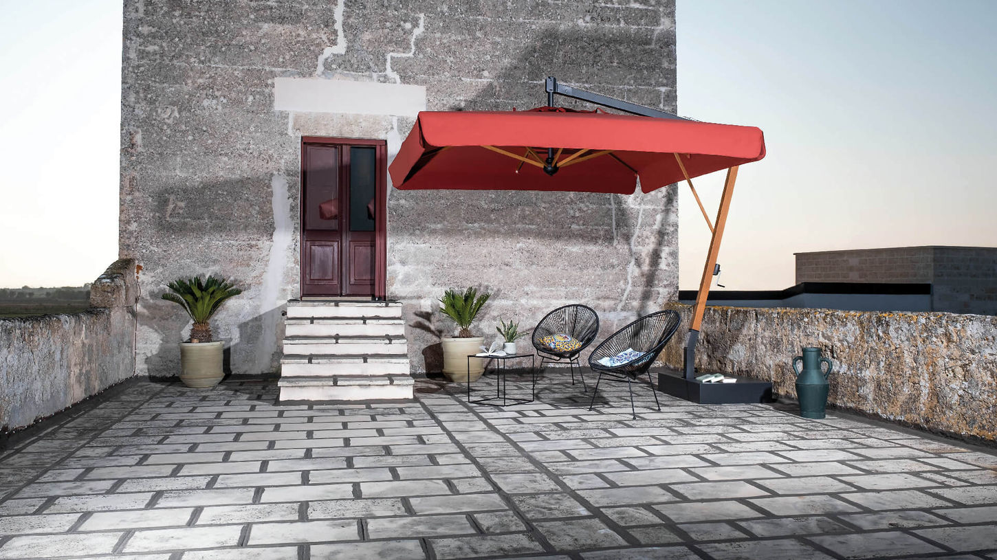 червона парасоля на терасі біля будинку