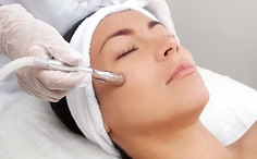 The cosmetologist makes the procedure Microdermabrasion of the facial skin of a beautiful,
