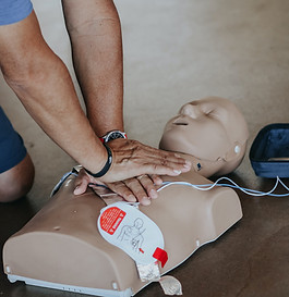 Person performs chest compressions on CPR training dummy