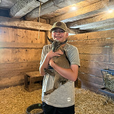 teen boy holding a baby goat