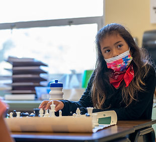 A student thinking about her next chess move