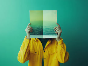 A man holding up an image on a teal background