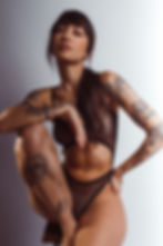 Garota sentada usando um body de tule com detalhes em ouro
